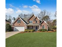 Charming two-story brick home with a well-manicured lawn and beautiful landscaping at 6320 Rutherford Pl, Suwanee, GA 30024