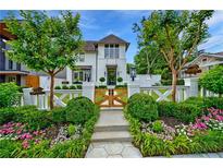 Charming white home featuring a landscaped front yard, wooden gate, and manicured bushes at 405 9Th Ne St, Atlanta, GA 30309