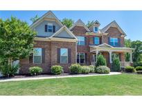 Charming two-story brick home with manicured lawn and inviting front porch at 6040 Ashborough Park, Cumming, GA 30040