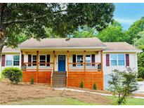 Charming single-story home with a covered front porch and well-maintained landscaping at 112 Village Ct, Woodstock, GA 30188