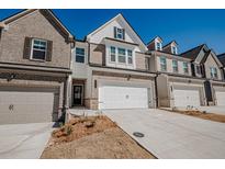 Charming townhouse with brick and siding exterior, two-car garage, and well-manicured front yard at 2777 Lou Lou Ln, Buford, GA 30519