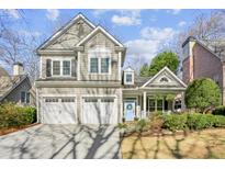 Charming home featuring a two-car garage, a welcoming light blue front door, and beautiful landscaping at 4164 Gateswalk Se Dr, Smyrna, GA 30080