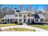 Stately white brick home featuring a columned front porch and manicured landscaping creating a welcoming curb appeal at 5430 Burdette Se Rd, Mableton, GA 30126