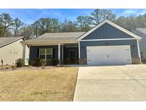 Charming blue single-story home featuring an attached two-car garage and well-maintained front yard at 8325 Loch Lomand Ln, Winston, GA 30187