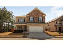 Charming two-story home features a brick and stone facade, complemented by a well-manicured lawn and two-car garage at 125 Sunland Blvd, Mcdonough, GA 30253