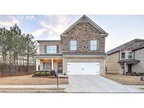 Charming two-story home featuring a brick and stone facade, a two-car garage, and a well-manicured front lawn at 125 Sunland Blvd, Mcdonough, GA 30253
