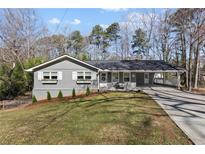 Charming single-story home featuring gray siding, white trim, and a well-manicured lawn in a suburban setting at 1300 Valley Ct, Roswell, GA 30075