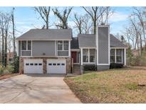 Charming home with a two-car garage, stone accents, and a well-maintained front lawn at 1575 Kelleys Close, Stone Mountain, GA 30088