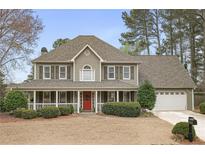 Charming two-story home with a large front porch, manicured lawn, and two-car garage at 6011 Fairlong Nw Ct, Acworth, GA 30101