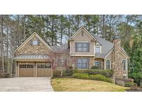 Stunning two-story home featuring a stone and siding exterior, two-car garage, and professionally landscaped yard at 2290 Dragonfly Nw Ct, Acworth, GA 30101