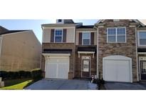 Charming townhome featuring brick and siding exterior, garage, and well-maintained landscaping at 2102 Executive Dr, Duluth, GA 30096