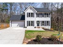 Charming two-story home with fresh white siding, a black roof, and a well-manicured front yard at 110 Compton Hall Dr, Alpharetta, GA 30005