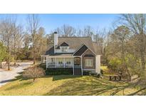 Charming home featuring a cozy front porch, stone accents, and mature trees at 129 Euharlee 5 Forks Rd, Euharlee, GA 30145