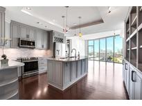 Modern kitchen with gray cabinets, stainless steel appliances, and a large island with granite countertops at 4561 Olde Perimeter Way # 702, Atlanta, GA 30346
