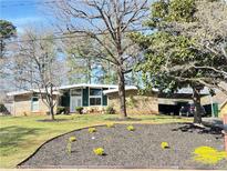Charming brick home with a well-manicured lawn, mature trees, and a convenient carport at 2470 Due West Nw Cir, Kennesaw, GA 30152