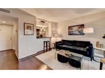 Inviting living room featuring hardwood floors, plush seating, and an open layout with a view into the kitchen at 275 13Th Ne St # 310, Atlanta, GA 30309