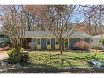 Charming single story home with a freshly cut lawn, mature landscaping, and blue accents at 621 Spruce Dr, Stone Mountain, GA 30083