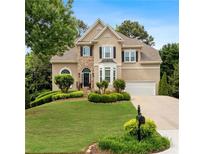 Charming two-story home featuring a stone facade, well-manicured lawn, and lush landscaping at 3640 Ridgeway Ter, Suwanee, GA 30024