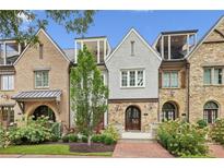 Charming townhomes showing a combination of stone and brickwork, complemented by lush green landscaping, arched doorway and small terraces at 55 Church St, Alpharetta, GA 30009