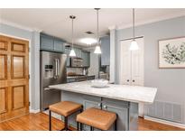 Stylish kitchen features stainless steel appliances, an island with bar seating, and lovely cabinetry at 214 Ridley Howard Ct, Decatur, GA 30030