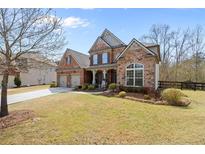 Charming brick and stone home with a manicured lawn and an attached two-car garage at 5865 Chestnut Dr, Cumming, GA 30040