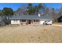 Charming single-story home featuring a well-maintained front yard, white picket fence and attached garage at 230 Laurel Way, Covington, GA 30016