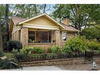 Charming brick home with a well-manicured lawn, decorative fence, and inviting front porch at 434 Euclid Ne Ter, Atlanta, GA 30307