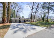 Street view of a well-maintained home with a long driveway and mature trees at 4985 Crowe Se Dr, Smyrna, GA 30082