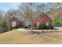 Charming brick home with a well-manicured lawn and mature trees in a serene setting at 2020 Huntington Hill Trce, Buford, GA 30519