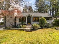 Charming brick home with a well-manicured lawn and mature landscaping at 1011 Lindridge Ne Dr, Atlanta, GA 30324