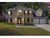 Charming two-story brick home boasts a well-manicured lawn and attached two-car garage at 118 Bellington Dr, Mcdonough, GA 30253