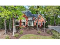 Elegant two-story red brick home with well-manicured lawn and professional landscaping at 2975 Coles Way, Atlanta, GA 30350