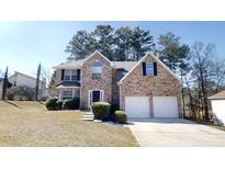 Charming two-story brick home with a two-car garage and well-manicured landscaping at 6643 Hill Creek Cv, Lithonia, GA 30058
