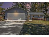 Charming home features a two-car garage, fresh landscaping, and a freshly sealed driveway at 284 Regal Dr, Lawrenceville, GA 30046