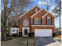 Beautiful two-story brick home with a well-manicured lawn and a two-car garage at 3242 Monarch Pine Nw Dr, Peachtree Corners, GA 30071