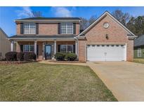 Charming two-story brick home with a well-manicured lawn and attached two-car garage at 9005 Aldbury Dr, Locust Grove, GA 30248