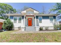 Charming home featuring an inviting orange front door, blue and white exterior, and landscaped front yard at 1497 Rogers Sw Ave, Atlanta, GA 30310