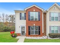 Charming two-story townhome featuring brick and vinyl siding, black shutters and a well-maintained lawn at 8409 Carlington Ln, Jonesboro, GA 30236