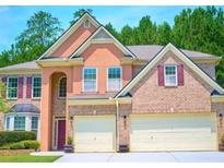 Stunning two-story home with a two-car garage, manicured lawn, and lush green trees in the background at 1172 Preserve Park Dr, Loganville, GA 30052