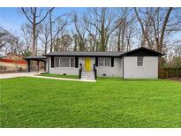 Charming, renovated single-story home with a well-manicured lawn and a bright yellow front door at 3534 Spring Cir, Decatur, GA 30032