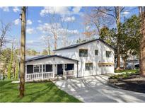 Beautifully renovated home boasts a modern exterior, front porch, and an inviting driveway at 7410 Fields Dr, Cumming, GA 30041
