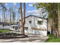 Charming two-story home with white siding, black trim, attached garage and a well-manicured front yard at 7410 Fields Dr, Cumming, GA 30041