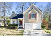 Charming home featuring a two-car garage, red front door, and well-maintained lawn at 833 River Valley Dr, Jonesboro, GA 30238