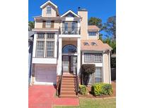 Charming multi-level home featuring a quaint front balcony, a garage, and a neatly landscaped front yard at 2270 Goodwood Se Blvd, Smyrna, GA 30080
