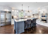 A spacious kitchen with a center island, stainless steel appliances, and white cabinetry at 1812 Anthony Nane Ct, Lawrenceville, GA 30043