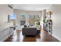 Bright living room features hardwood floors, large windows, and a cozy seating area at 1 Biscayne Nw Dr # 211, Atlanta, GA 30309
