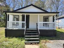 Charming home featuring a cozy porch, freshly painted in a classic black and white color scheme at 5160 Avery St, Covington, GA 30014