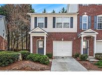 Charming brick townhouse with a one-car garage and well-maintained landscaping at 2173 Dillard Xing, Tucker, GA 30084