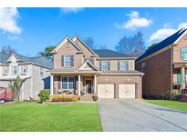 Charming two-story brick home featuring a welcoming front porch and a well-manicured lawn at 2591 Royston Dr, Duluth, GA 30097