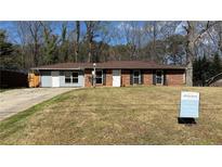 Charming single-story brick home with a well-maintained lawn and mature trees at 781 E Glochester Pl, Norcross, GA 30071